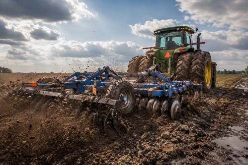 Heavy-duty disc harrow operating in large-scale agricultural farming conditions Heavy-duty disc harrow operating in large-scale agricultural farming conditions
