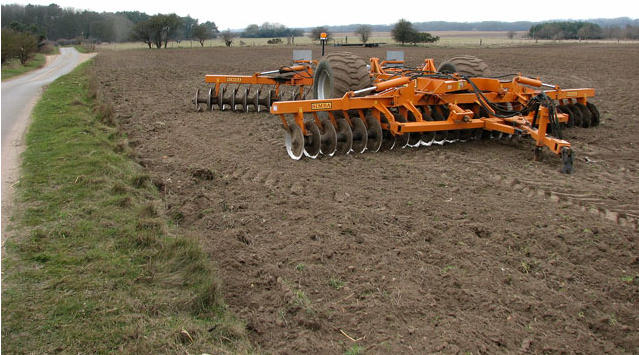 Disc harrow working in agricultural soil preparation environment